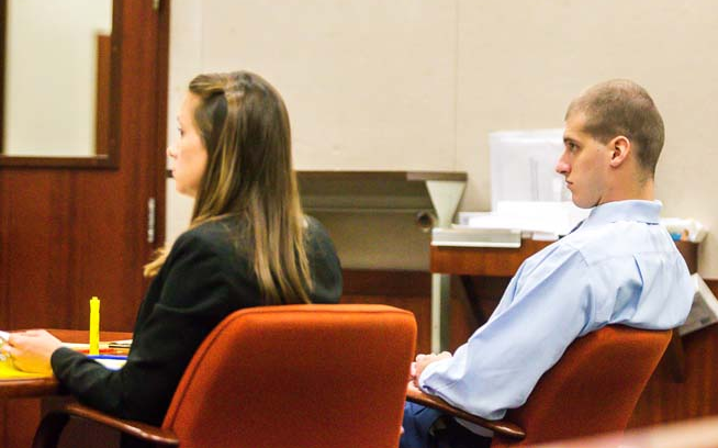 Attorney Naumann in court with a client, seated-criminal defense lawyer for Vero Beach, FL